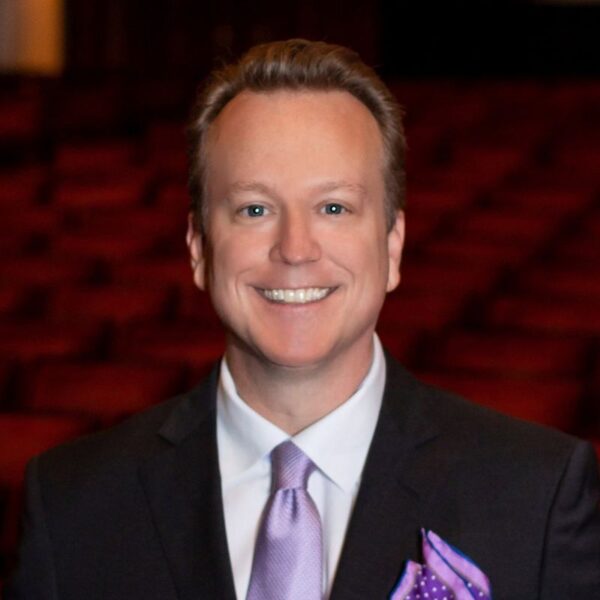 David Walker, a smiling man in a suit with a purple tie, photo credit Coastal Click Photography